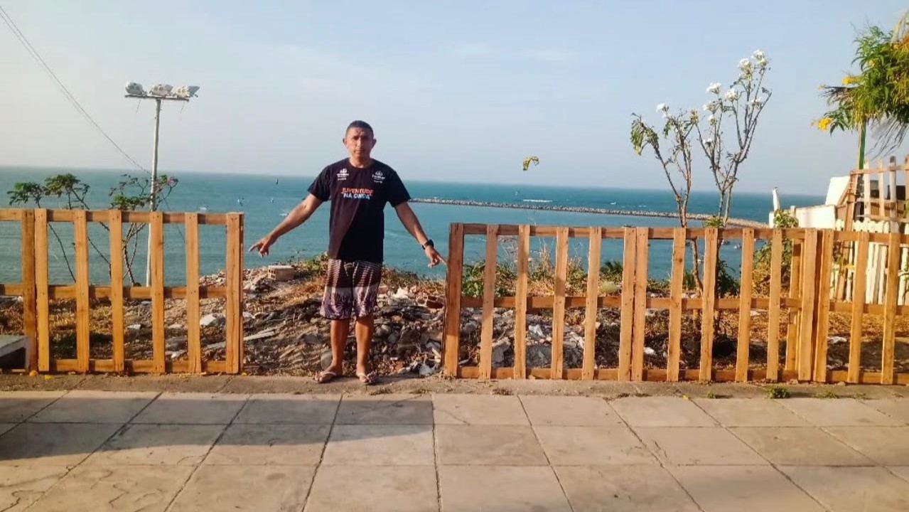 Jean Cruz posa na frente de uma cerca de madeira